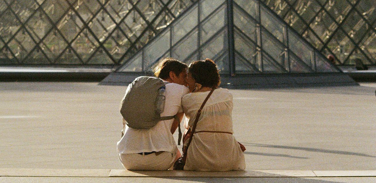 Droit à l'image en street photography - exemple de photo illégale - Couple de dos s'embrassant devant la Pyramide du Musée du Louvre à Paris