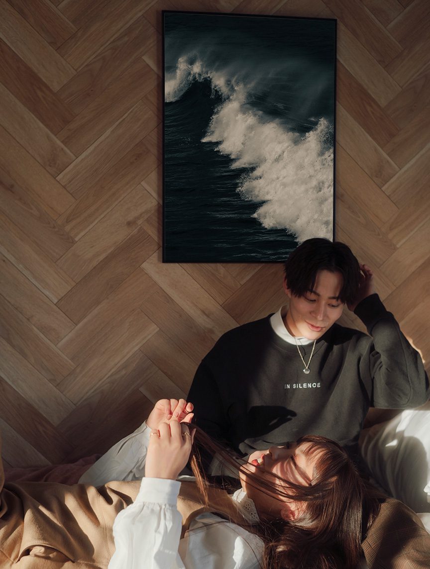 Couple complice sur un canapé devant un tirage photo d'art maritime